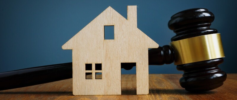 Property deed and legal balance representing family settlement disputes